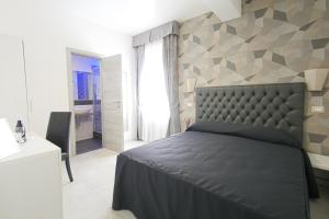 een slaapkamer met een groot bed en een badkamer bij Hotel Terrazza Magenta in Rome
