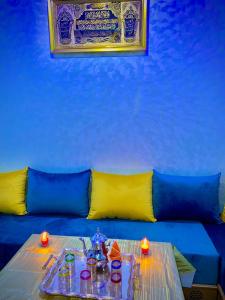- un canapé bleu avec une table et des bougies dans l'établissement Sahrawi Abdo, à Errachidia