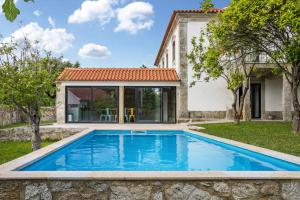 una piscina en el patio trasero de una casa con una casa en Casa do Mestre T2, en Vila de Punhe