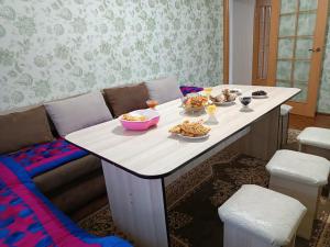 een tafel met borden eten erop bij Guest house Ayperi in Bokonbayevo