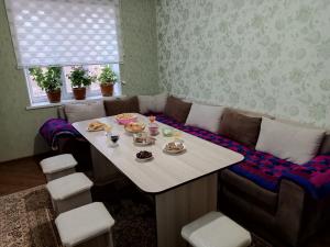 uma sala de estar com uma mesa e um sofá em Guest house Ayperi em Bokonbayevo