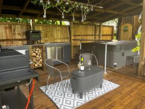 un patio con griglia, tavolo e pianoforte di Lynbrook Haybarn, Hot tub and outdoor kitchen, New Forest a Ringwood