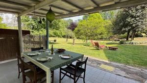 a green table and chairs on a patio at Fuga nella Natura - Rustico a pochi minuti dal lago di Lugano in Cuasso Al Monte
