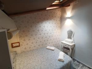 Dormitorio pequeño con cama y lavamanos en La Casita, en Gijón