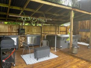 une terrasse avec un grill et un barbecue dans l'établissement Lynbrook Haybarn, Hot tub and outdoor kitchen, New Forest, à Ringwood