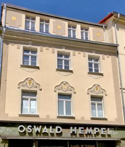 un edificio con un cartel en el costado en Oswald Hempel 5 Zimmermaisonette und 3 Zimmer Loftwohnung, en Zittau