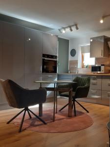 eine Küche mit einem Esstisch und 2 Stühlen in der Unterkunft Apartments Am Spitalthor in Straubing