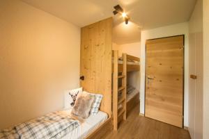 ein Schlafzimmer mit einem Bett und einem Etagenbett in der Unterkunft Chalet Sunneblick in Grindelwald