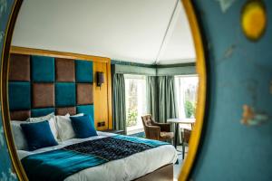 a bedroom with a bed and a mirror at Duisdale House Hotel in Isleornsay