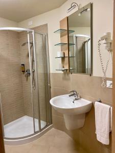 a bathroom with a shower and a sink and a shower at Hotel Campagnola in Malcesine