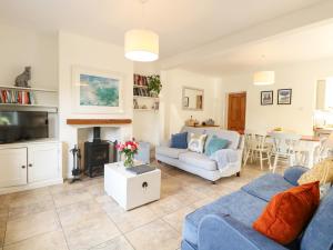 a living room with a blue couch and a fireplace at 8 Melinda Cottage in Cromer