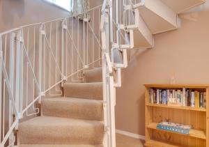 a spiral staircase in a home with a book shelf at Smugglers Cove Cottage in Ravenscar