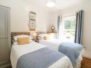 two beds in a room with a window at 8 Melinda Cottage in Cromer