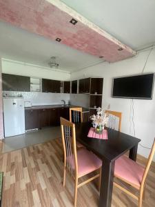 a kitchen and dining room with a table and chairs at Zimbrului Apartment in Bistriţa