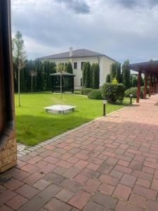 a house with a park with a bench in the grass at Zimbrului Apartment in Bistriţa