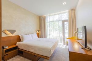 Rúm í herbergi á NEW Rixwell Collection Seaside Hotel Jurmala