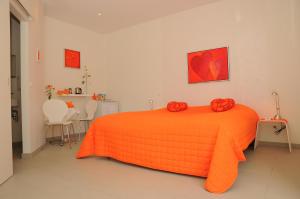 een slaapkamer met een bed met een oranje deken bij Hotel CoCo Aps in Esbjerg +16 foto's