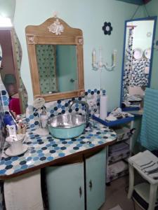 a bathroom with a sink and a mirror on a counter at Stanza privata casa artistica Mariola in San Sperate
