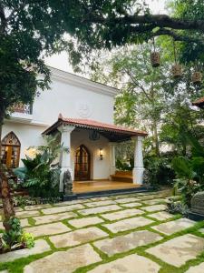 a small white house with a stone patio at The Postcard Saligao in Calangute