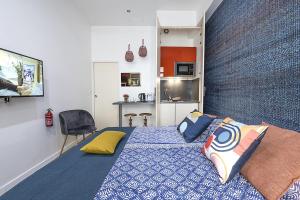 a bedroom with a blue bed with pillows on it at Le petit Claude Bernard - studio cosy Bellecour in Lyon