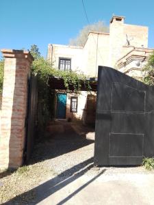een ingang naar een huis met een zwarte poort bij Duplex, Córdoba zona norte in Cordoba