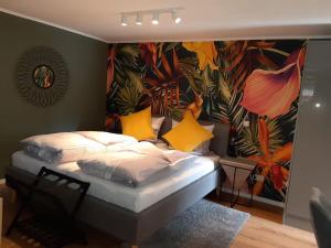 a bed with yellow pillows in a room with a mural at Apartments Am Spitalthor in Straubing