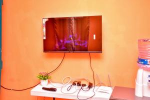 a flat screen tv hanging on a wall at CasaAloha Homes- Cozy 1Bdr - Along Eldoret-Kisumu Highway - Near the Edge Bar and Restaurant in Eldoret