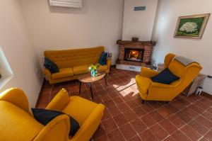 a living room with yellow couches and a fireplace at Entire house in the center of Ljubljana - FREE PARKING - Dragon Garden Pavilion Ljubljana in Ljubljana