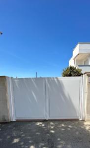 a white privacy fence in front of a house at Villa Antonia sul mare con piscina Torre a mare (Bari) in Bari