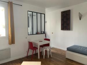 a room with a table and two chairs and a bed at Studio perfect for 2 adults and 1 kid, and up to 2 kids - Jourdain 20e, 25mn to Louvre via line M11 in Paris