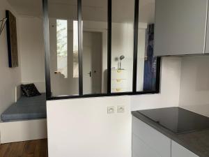 a kitchen with white cabinets and a bed in it at Studio perfect for 2 adults and 1 kid, and up to 2 kids - Jourdain 20e, 25mn to Louvre via line M11 in Paris