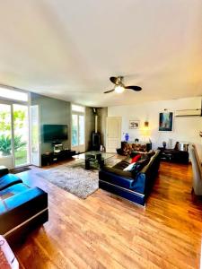 Una sala de estar con un sofá y un ventilador de techo. en Holiday house in the city-center of Antibes with a private pool, en Antibes
