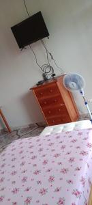 馬爾多納多港的住宿－koryares haushostel，一间卧室配有一张床、梳妆台和风扇