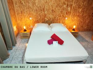 łóżko z czerwonym krzyżem na górze w obiekcie TI ZAZAKEL w mieście Saint-Denis