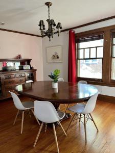 a dining room with a wooden table and white chairs at Historic Oak Park Residence in Oak Park