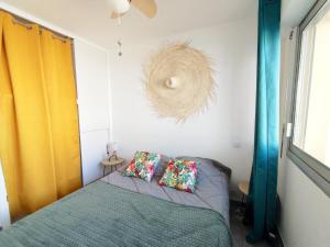 um quarto com uma cama com duas almofadas em Superbe T2 au calme avec balcon sur la marina - 10 em Canet-en-Roussillon