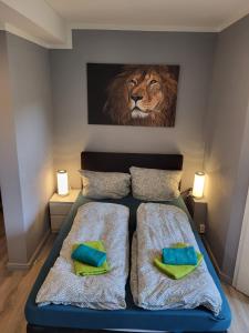 - une chambre avec un lit orné d'une peinture sur lion sur le mur dans l'établissement Flensburg City - 24h, à Flensbourg