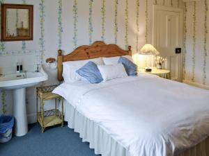 a bedroom with a large white bed and a sink at Sunnyside in Balnald