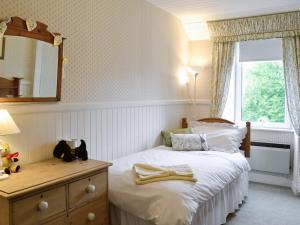 a bedroom with a bed with a dresser and a window at Sunnyside in Balnald