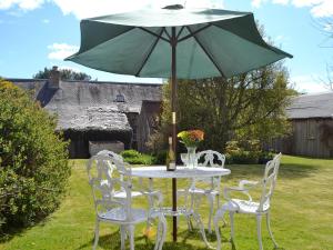 a table and chairs with an umbrella in a yard at Sunnyside in Balnald