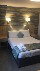 a hotel room with a bed with two lamps on it at Caledonian Hotel 'A Bespoke Hotel’ in Ullapool