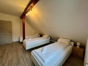Habitación pequeña con 2 camas y suelo de madera. en Panorama Apartments, en Bovec
