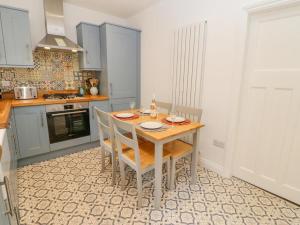 uma cozinha com uma mesa de madeira e cadeiras em Tower Street Cottage em Richmond