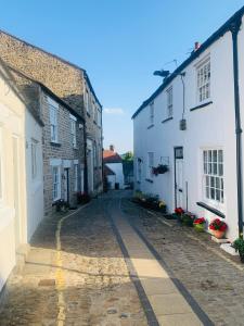 an empty cobblestone street in a town with white buildings at Tower Street Cottage in Richmond