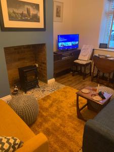 a living room with a fireplace and a tv at Tower Street Cottage in Richmond