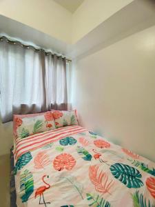 een slaapkamer met een bed met een bloemenbed bij Casa Lim SMDC Light Residences Tower 3 in Manilla