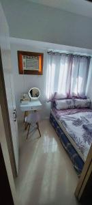 1 Schlafzimmer mit einem Bett mit einem Schreibtisch und einem Bett mit einem sidx sidx sidx in der Unterkunft Casa Lim SMDC Light Residences Tower 3 in Manila