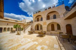 a courtyard with tables and chairs in a building at PALMYRA BOUTIQUE HOTEL in Urfa