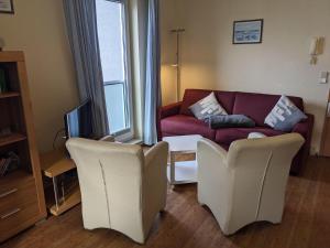 ein Wohnzimmer mit einem Sofa und 2 Stühlen in der Unterkunft Yachthafenresidenz - Wohnung 6201 / 742 in Kühlungsborn