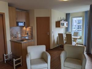 ein Wohnzimmer mit einer Küche und einem Esszimmer in der Unterkunft Yachthafenresidenz - Wohnung 6201 / 742 in Kühlungsborn